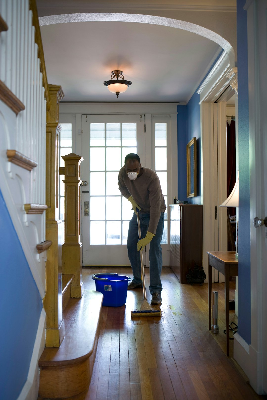project-01-b This African-American man was in the process of damp-mopping his home’s entrance way. In this way airborne particulates including dust and pollen, could be removed from the inside of his home, thereby, reducing the detrimental effects these substances have upon the respiratory system of his family members. These irritants can sometimes result in sinus infections, and asthma.